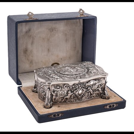 A Swiss Silver Plated Automaton Musical Box Of Serpentine Outline Decorated With Putti In Forest